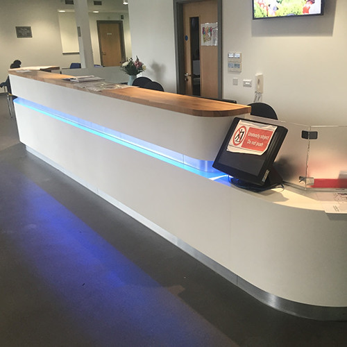 Hanex solid surface reception desk with solid oak top and LED lighting